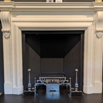 Chesneys Durham fireplace with Morris fire basket for dogs and Burton andirons in showroom
