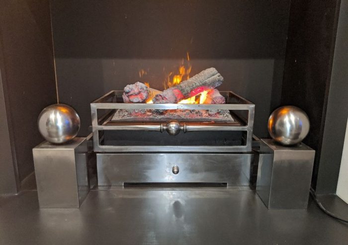 Chesneys Olympus electric fire, Byron fire basket for dogs and Spherical Steel fire dogs in showroom